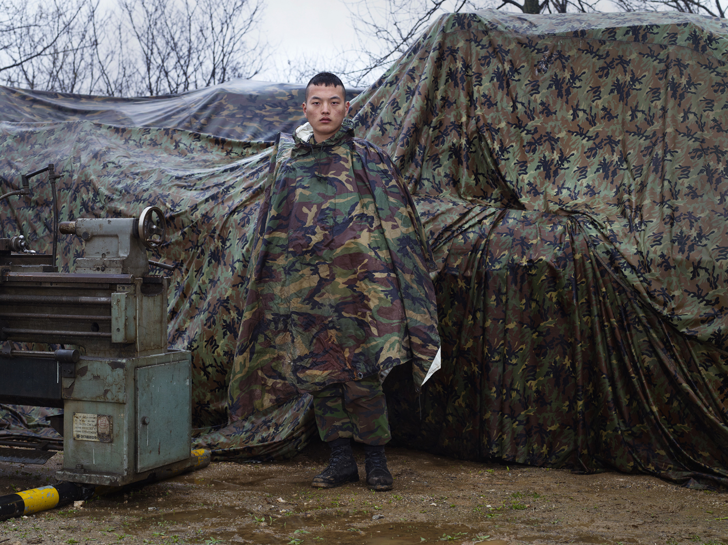 17 판초우의를 입고 위장 막앞에 선 군인, Archival Ink-jet Print, 104x138cm, 2011